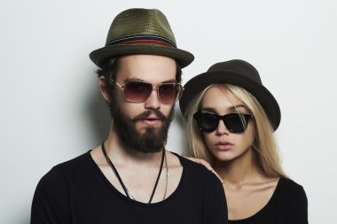 güzel çift şapkalı trendy gözlüklü. Hippi erkek ve kız. Sakallı genç adam ve güneş gözlüklü sarışın model