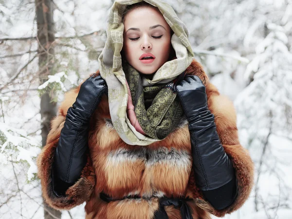 Menina modelo de beleza no tempo de inverno. bela jovem mulher na moda casaco de pele, luvas de couro e cachecol — Fotografia de Stock