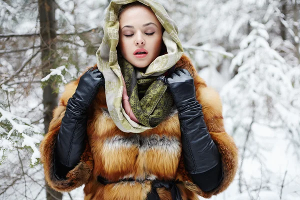 Modelo de beleza na floresta de inverno. bela jovem mulher na moda casaco de pele, luvas de couro e cachecol — Fotografia de Stock