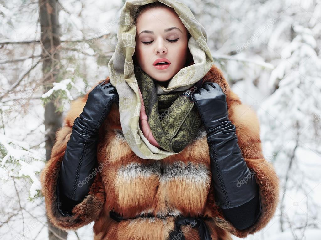 Beauty model girl in winter time. beautiful young Woman in fashionable Fur Coat,leather gloves and scarf