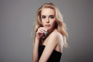 Moda portre sarışın saçlı güzel genç kadın. Siyah elbiseli kız