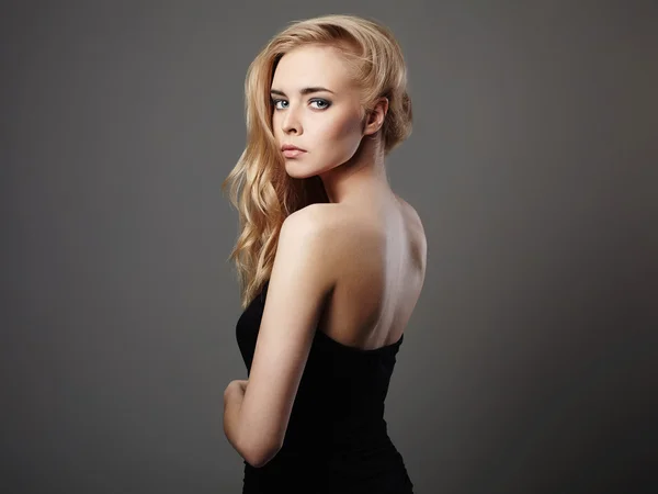 Fashion portrait of beautiful young woman with blond hair. Girl in black dress — Stock Photo, Image