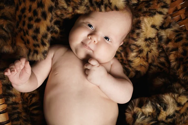 Bebé recién nacido sonriente en piel de animal.niño pequeño divertido — Foto de Stock