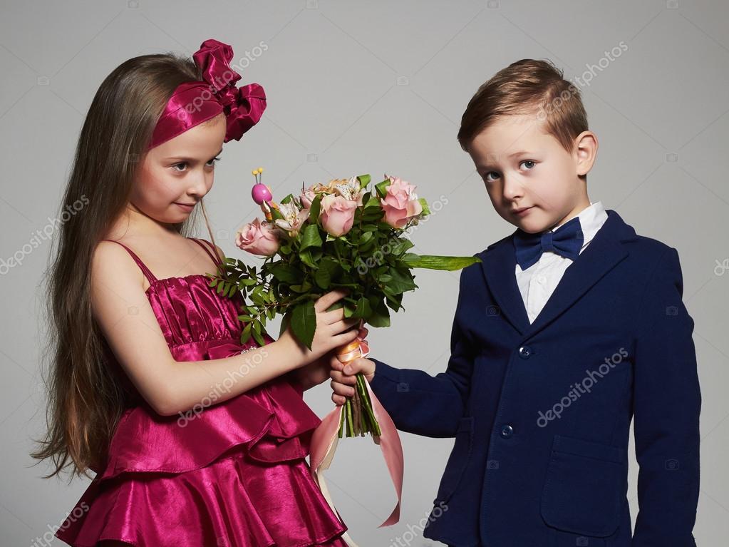 Boy gives a girl flowers.little beautiful couple.kids love,roses