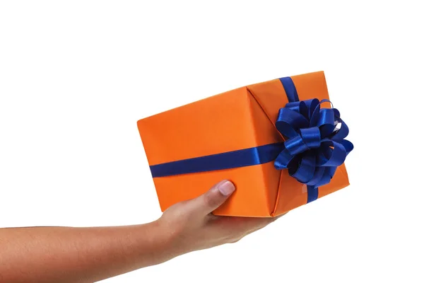Rozdávat velkých dárek zabalený v oranžovém rámečku s modrou stužkou a luk. — Stock fotografie
