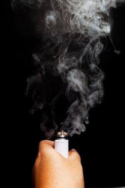 E-sigara/e-cig/vape kullanarak ele. Ve bir duman rebuildable damla atomizer (Rda) koyu renk arka plan üzerinde bırakmadan, yakın çekim