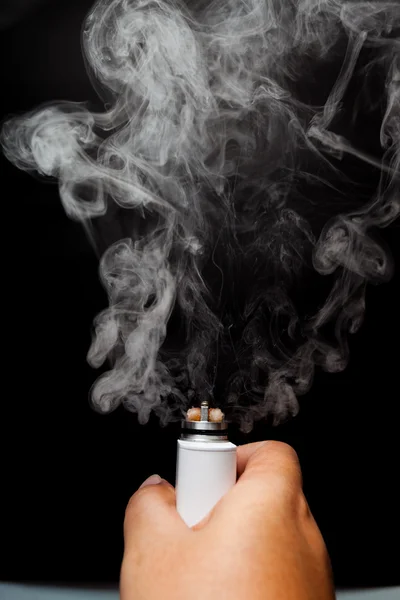 タバコ セエグ アークを使用しての手 濃い色の背景の上 Rebuildable 点滴アトマイザー Rda から煙を解放 クローズ アップ — ストック写真