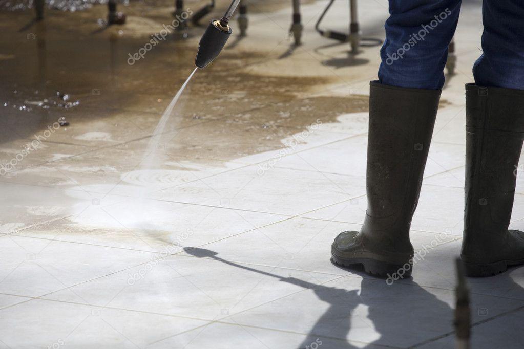 Worker Cleaning a Fountain by Pressure Washer
