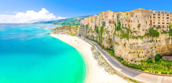 Trrhenian Denizi 'nin tropea kasabası ve sahil kıyılarının hava panoramik manzarası. Turkuaz masmavi su, yüksek kayaların tepesindeki renkli evler, deniz kenarındaki yol, Calabria, Güney İtalya