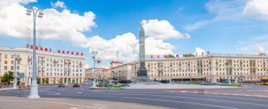 Minsk, Belarus, 26 Temmuz 2020: Zafer Anıtı 'nın panoramik manzarası ve binaların üzerindeki kırmızı harflerle insanların kahramanca eylemi ölümsüzdür, güneşli bir günde mavi gökyüzü