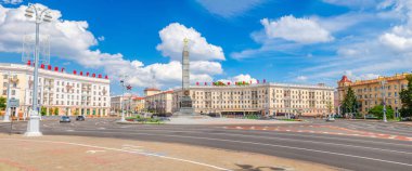 Minsk, Belarus, 26 Temmuz 2020: Zafer Anıtı 'nın panoramik manzarası ve binaların üzerindeki kırmızı harflerle insanların kahramanca eylemi ölümsüzdür, güneşli bir günde mavi gökyüzü