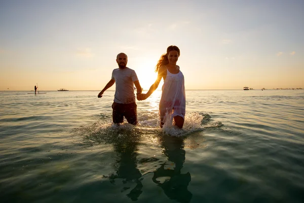Romantiskt par på stranden vid färgglad solnedgång på bakgrunden — Stockfoto