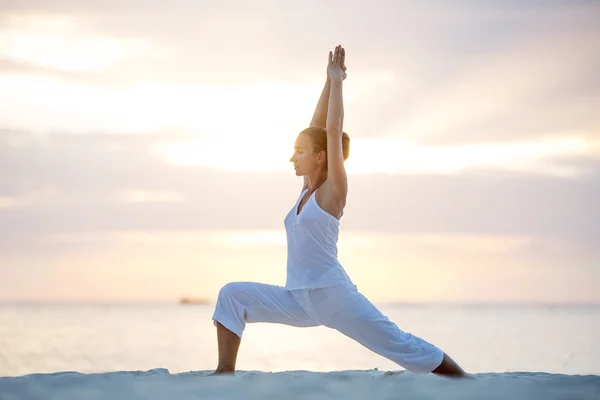 Mujer caucásica practicando yoga en la orilla del mar — Foto de Stock