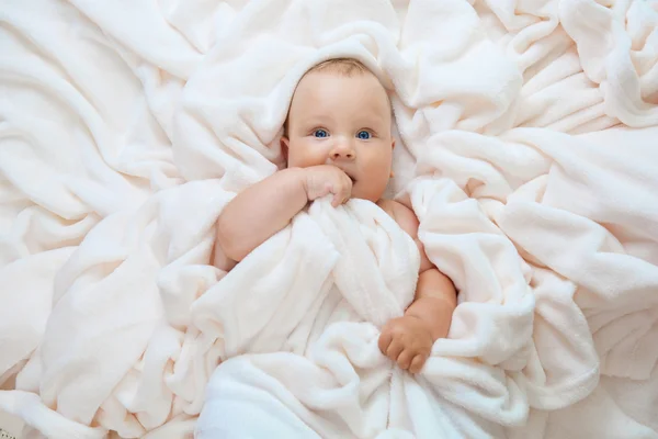 Caucásico bebé niño cubierto con toalla alegremente sonríe a la cámara — Foto de Stock