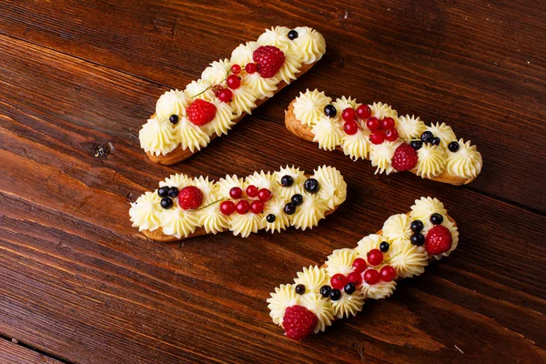 Eclairs på träbord — Stockfoto