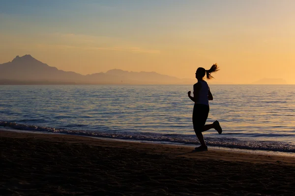 Белая женщина бегает по берегу моря — стоковое фото