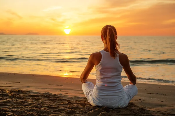 Mujer caucásica practicando yoga en la orilla del mar — Foto de Stock