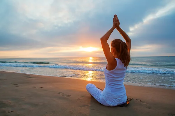 Femme caucasienne pratiquant le yoga au bord de la mer — Photo