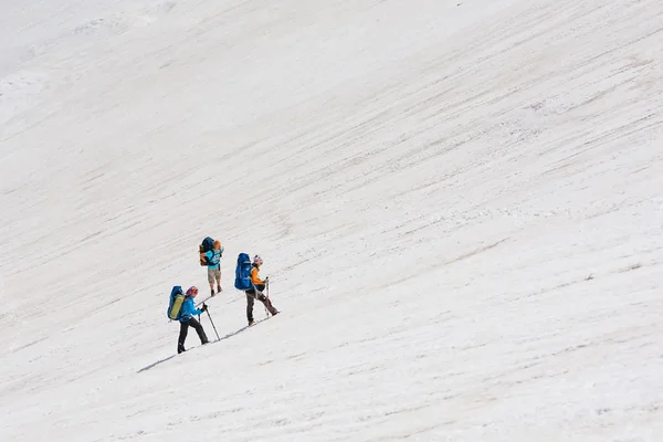 Mochileros están pasando campo de nieve en la montaña rocosa en Altai mo — Foto de Stock