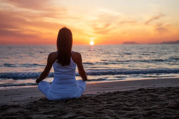 Kaukasisk kvinna utövar yoga på stranden — Stockfoto