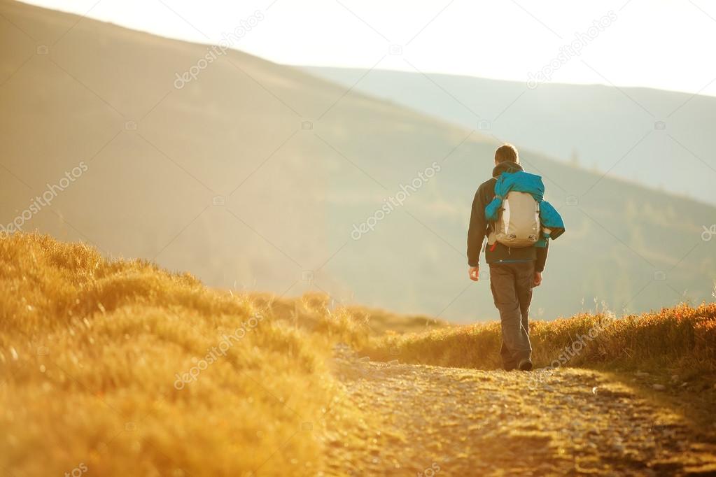 Hiker walking in autumn mountains
