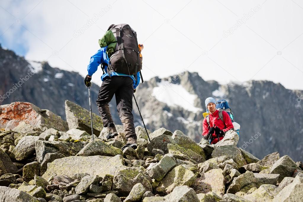 Hikers are climbing rocky slope of mountain in Altai mountains, 