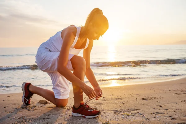 Kaukasisk kvinna jogging på havsstranden — Stockfoto