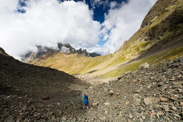 Georgia 'daki Kafkasya dağlarında sırt çantalı bir adam yürüyüş yapıyor. — Stok fotoğraf