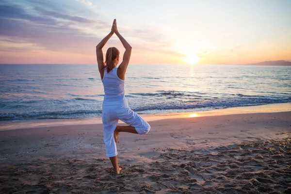 Mujer caucásica practicando yoga en la orilla del mar — Foto de Stock