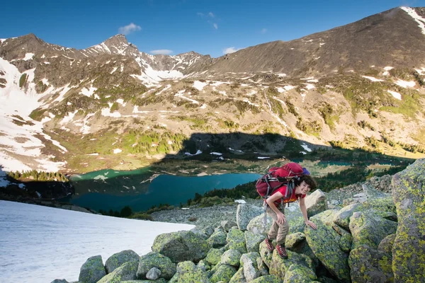 Senderista está escalando la ladera rocosa de la montaña en las montañas de Altai, Ru — Foto de Stock