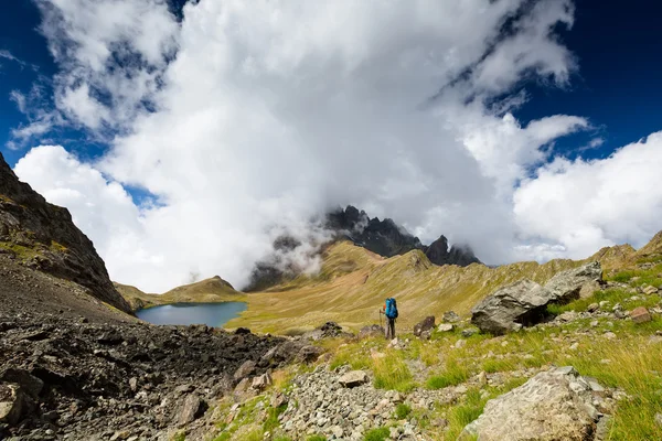 Georgia 'daki Kafkasya dağlarında sırt çantalı bir adam yürüyüş yapıyor. — Stok fotoğraf
