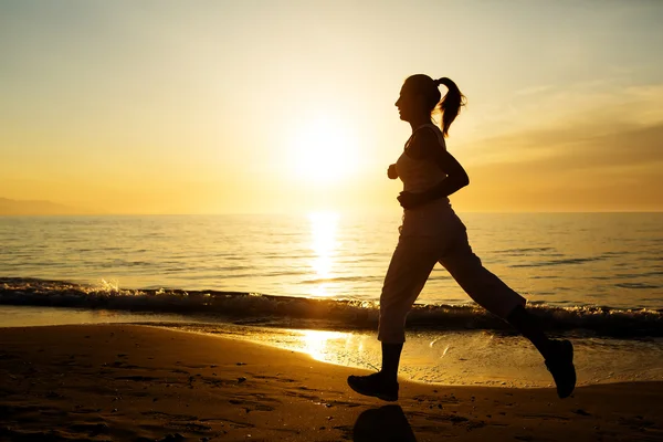 Kaukasisk kvinna jogging på havsstranden — Stockfoto