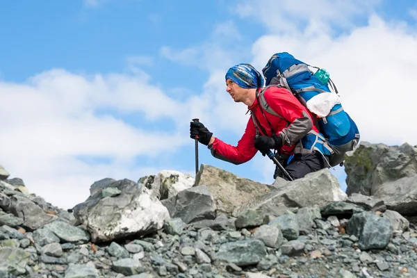 Senderista está escalando la ladera rocosa de la montaña en las montañas de Altai — Foto de Stock