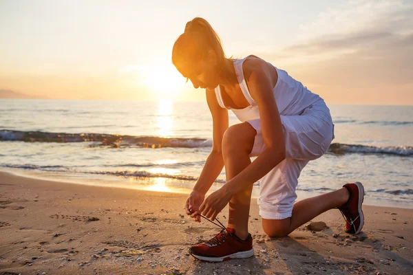 Kaukasische vrouw joggen op kust — Stockfoto