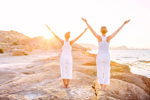 Mujer caucásica practicando yoga en la orilla del mar — Foto de Stock