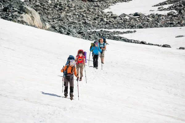 Mochileros están pasando campo de nieve en la montaña rocosa en Altai mo — Foto de Stock