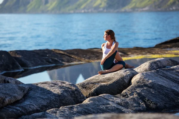 Junge Frau praktiziert Yoga zwischen Bergen in Norwegen — Stockfoto