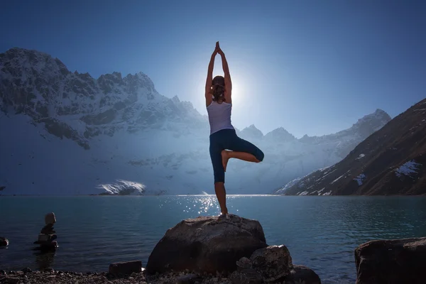 Молодая женщина практикует йогу на горном озере — стоковое фото