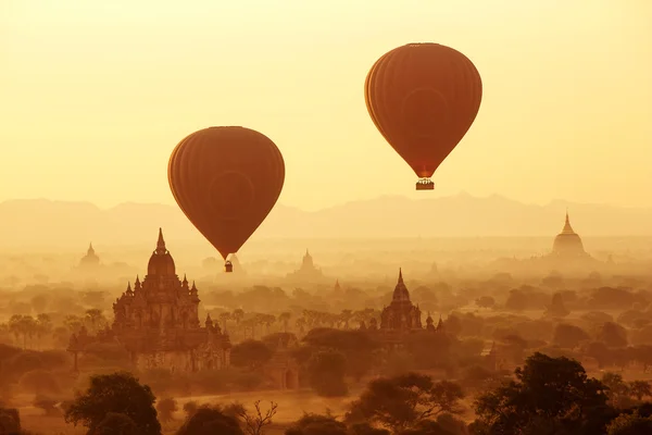 Balões de ar sobre templos budistas ao nascer do sol. Bagan, Myanmar . — Fotografia de Stock