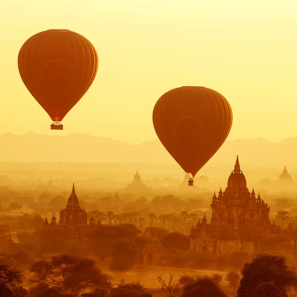 Luftballons über buddhistischen Tempeln bei Sonnenaufgang. bagan, myanmar. — Stockfoto