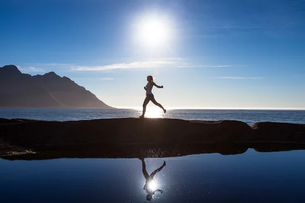 Mujer caucásica está saltando contra el océano azul en Noruega — Foto de Stock