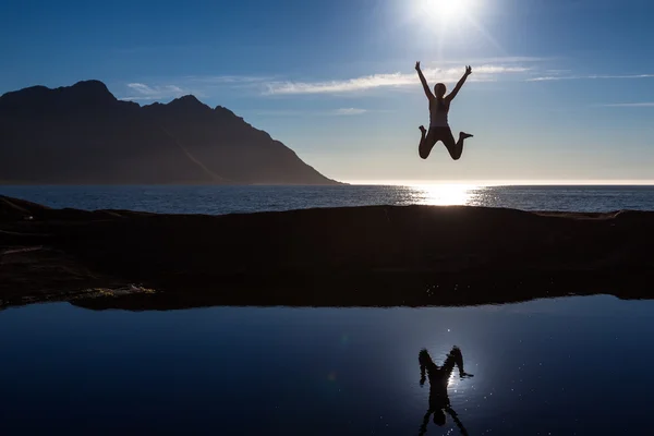 Mujer caucásica está saltando contra el océano azul en Noruega — Foto de Stock