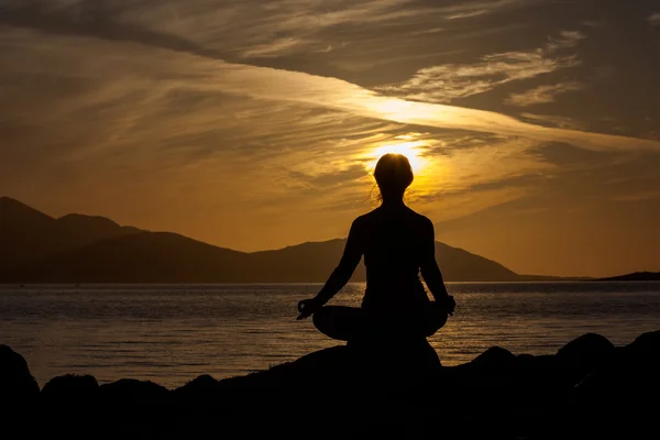 Caucasian woman is doing yoga excercises against picturesque lan