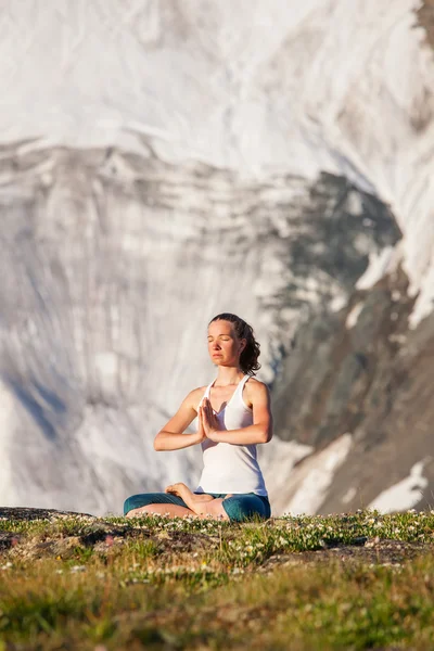 Ung kvinna utövar yoga i höga berg — Stockfoto