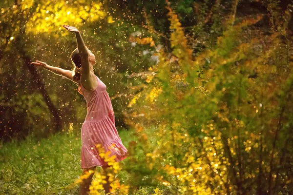 Pretty young woman under summer rain during a beautiful sunset — Stock Photo, Image