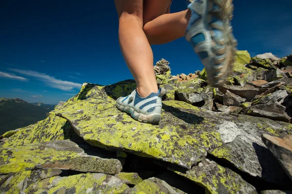 Senderista salta sobre piedras en montañas Cárpatos con pie cerca — Foto de Stock