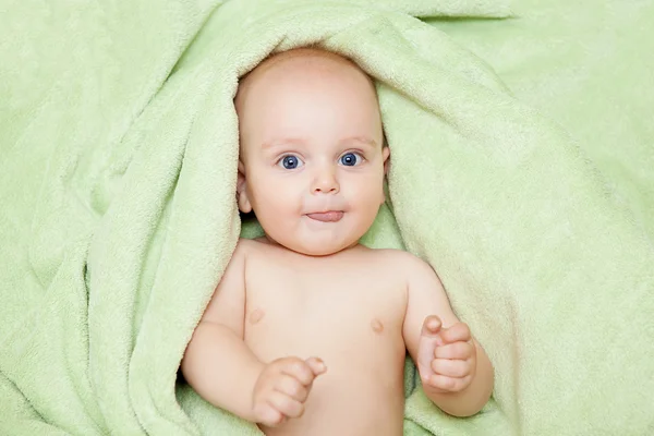 Caucasico bambino ragazzo coperto con verde asciugamano gioiosamente sorride a c — Foto Stock