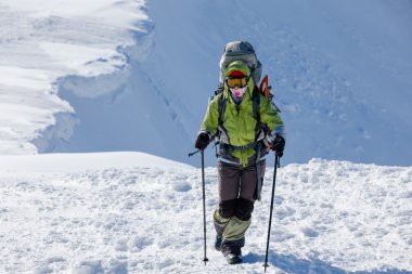 Backpacker kadın kış dağlarda güneşli günde yürüyor