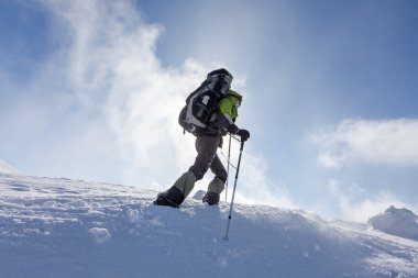Backpacker kadın kış dağlarda güneşli günde yürüyor