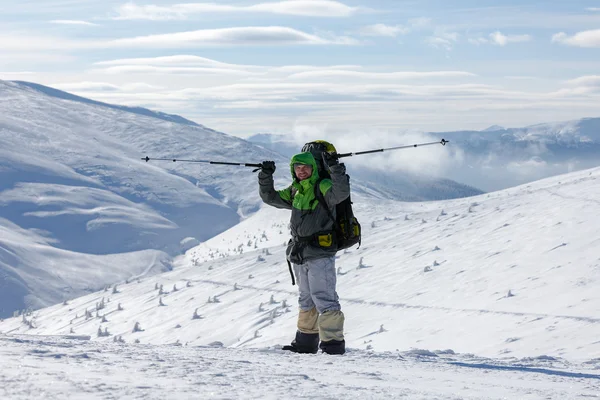 Homem mochileiro está posando em montanhas de inverno — Fotografia de Stock